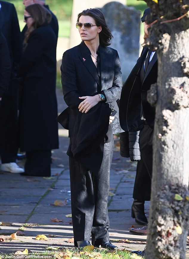 Damian Hurley waits outside with mourners before Payne's funeral