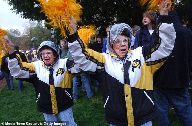 Twins Peggy Coppom, left, and Betty Hoover cheer on the Buffs years earlier