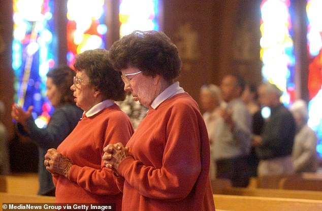 Peggy Coppom, left, and her sister Betty Hoover praying in church in 2005.