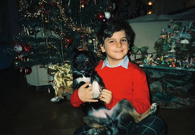 He also helped the homeless and stood up for bullied classmates at school. Pictured: young Acutis with his dog at Christmas