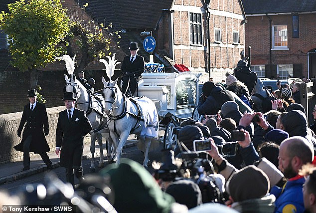 The hearse was pulled through the streets by two white horses with tufts of feathers