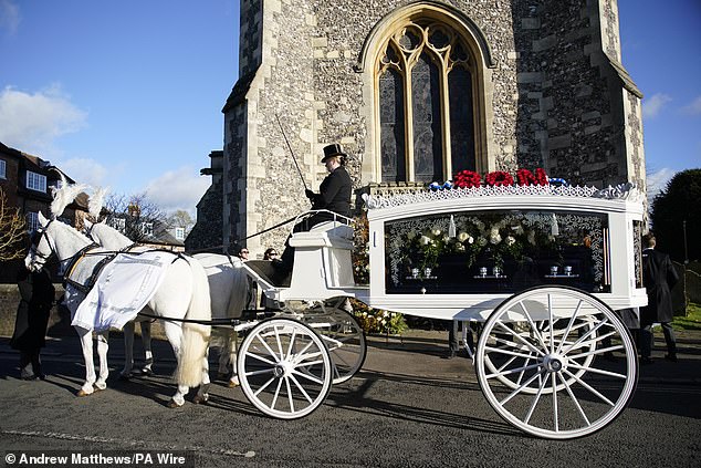 The horse-drawn carriage shines in the sun as the procession arrives at St. Mary's Church