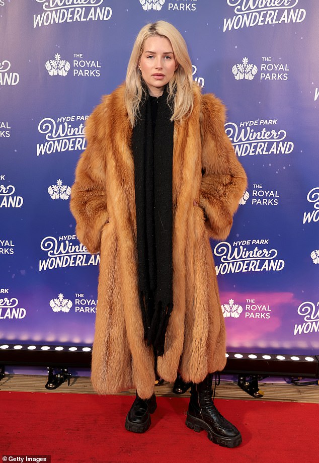 The model cut a chic figure while wearing an ankle-length red fur coat on the opening night of the festive event.