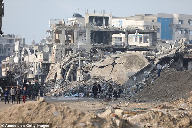 Palestinians return to their neighborhood to search for their belongings in the Shuja'iyya district after Israeli forces withdrew from the area in Gaza City, Gaza, on Tuesday.