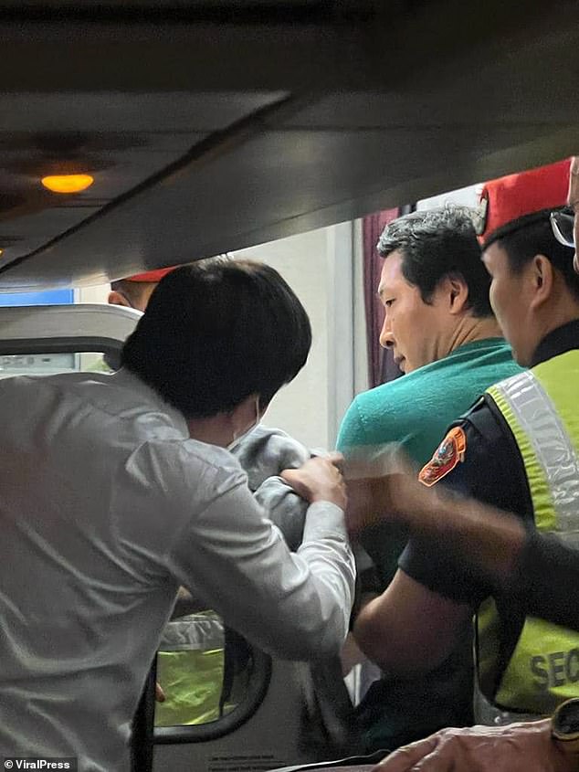 Heung is escorted off the plane. Police officers broke into the vehicle and arrested him and he was detained at the Phu Ping Ratchaniwet District Police Station.