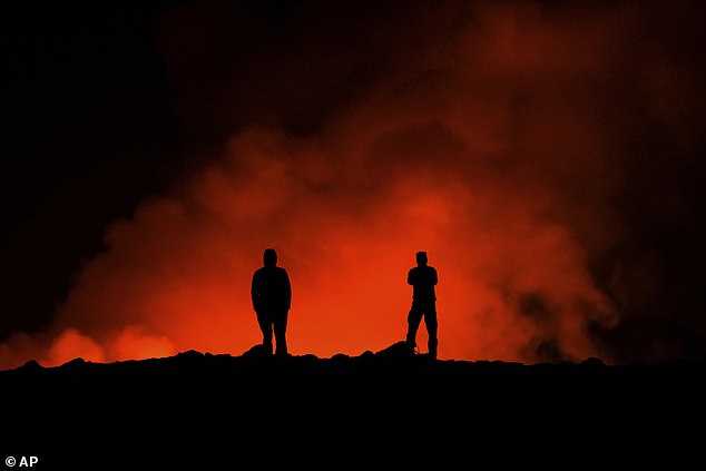 People watch the erupting volcano, north of Grindavik, Iceland, on Thursday