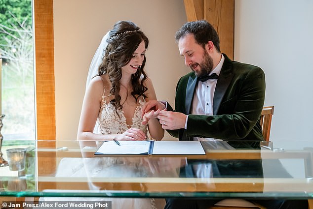 Jen, 27, and Tom, 28, pictured signing the register.