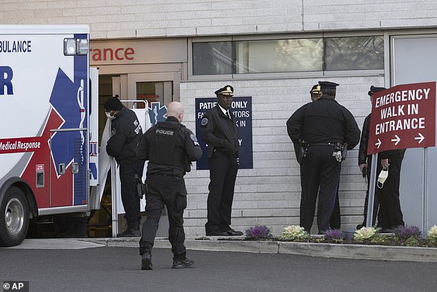 Police officers gather at the emergency entrance of Penn Presbyterian Medical Center while the two officers who were shot are inside.