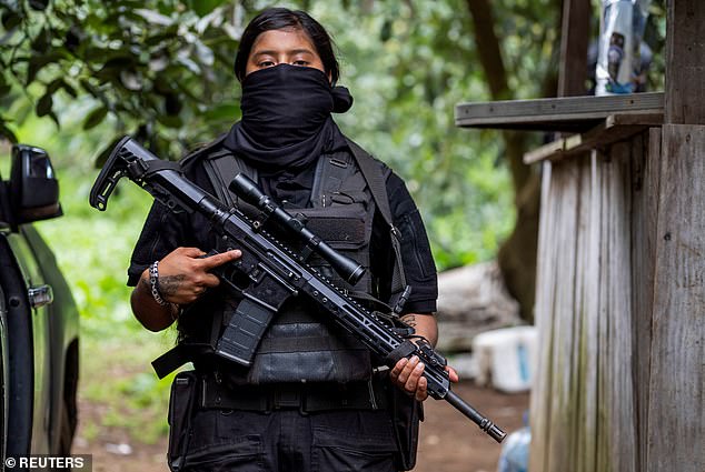 A female member of the Jalisco New Generation Cartel holds a sniper rifle.
