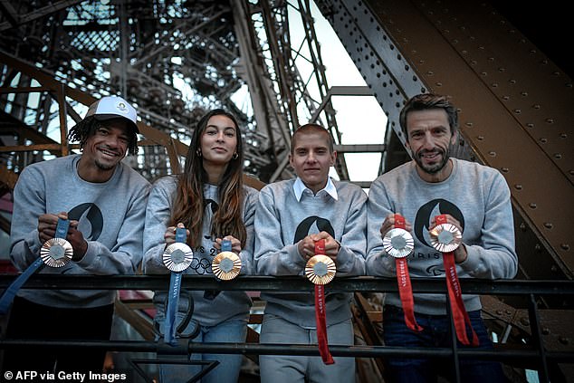 French athletes Arnaud Assoumani (left), Marie Patouillet (second left), Sara Balzer (second right) and Paris 2024 director Tony Estanguet (right) pose with Olympic medals.