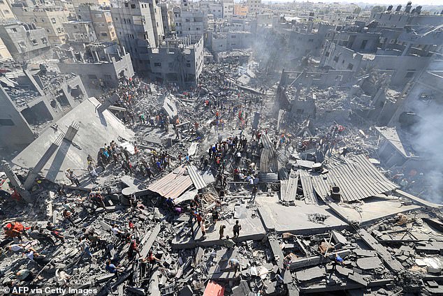 People search for survivors and the bodies of victims among the rubble of buildings destroyed during the Israeli bombardment, in Khan Yunis, southern Gaza Strip, on October 26.