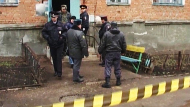 Scene of the massacre: police officers at the Kumertau apartment block where five young men were murdered