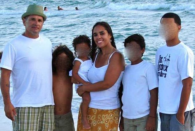 In happier times: Rick Adderly (aka Julian Paris), his wife Liza Nicole Adderly and their children pose together in a group photo on the beach.