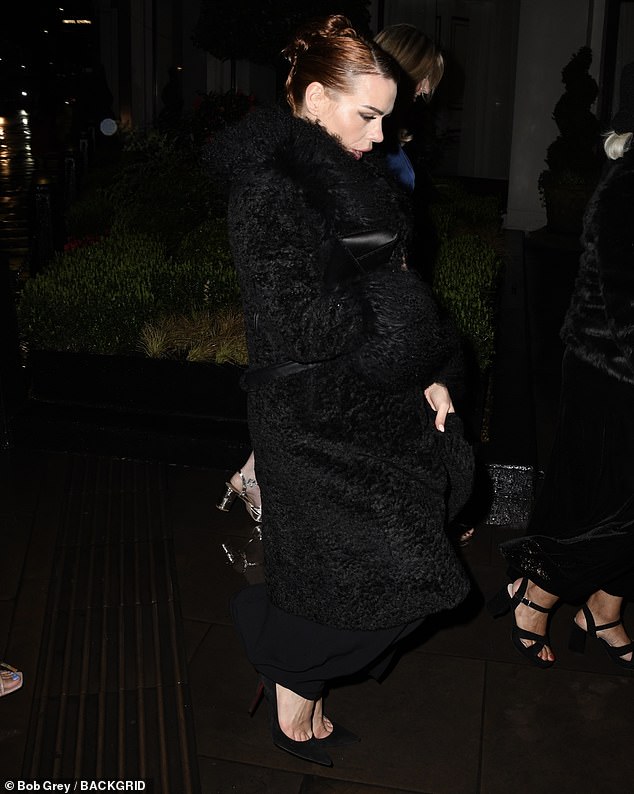 The actress covered her black dress with a huge fluffy black coat and held her purse and phone in one hand.
