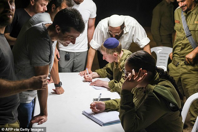 Reserve Israeli soldiers line up to register for duty in a northern Israeli town on October 7, after the Palestinian militant group Hamas launched a large-scale surprise attack on Israel.
