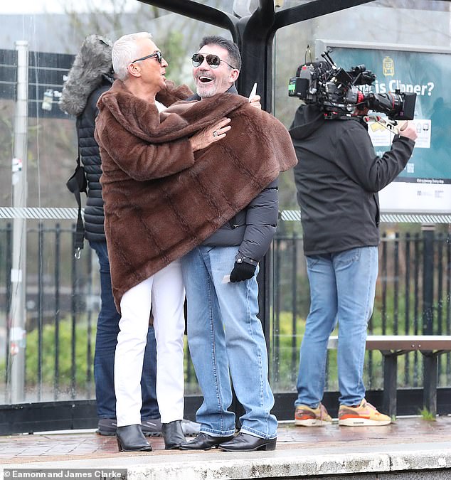 The judges were seen at the tram stop as Bruno kept Simon warm while wrapping the TV mogul in his brown fur coat.