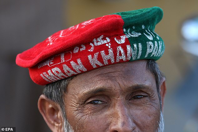 A supporter of convicted former Prime Minister Imran Khan wears a hat celebrating his party