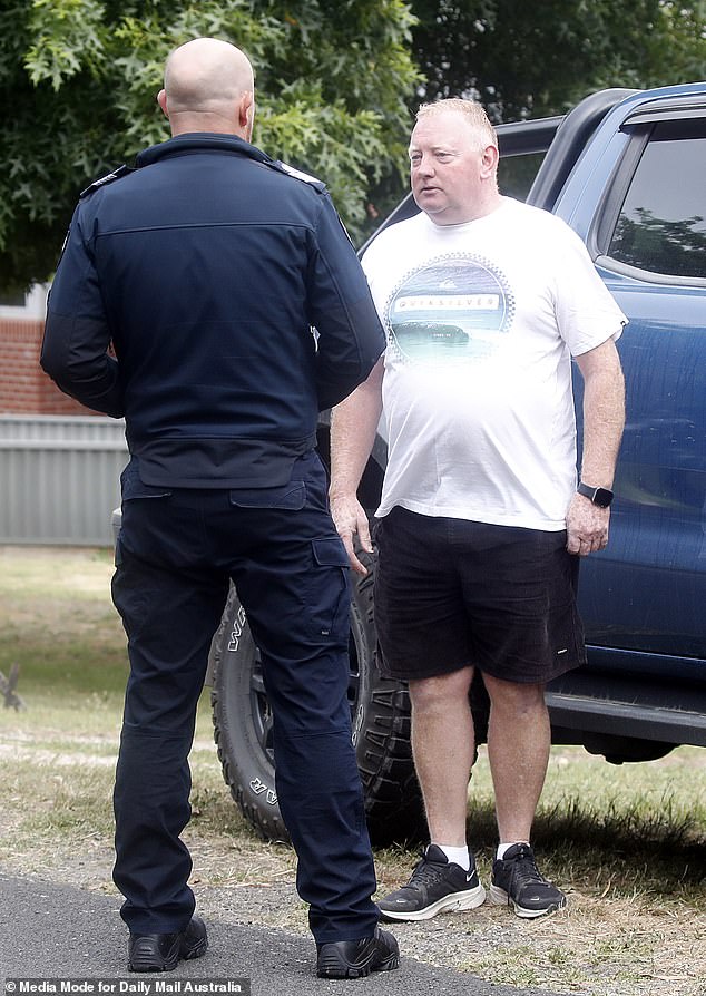 Murphy's husband, Michael, is seen speaking to police on Friday.