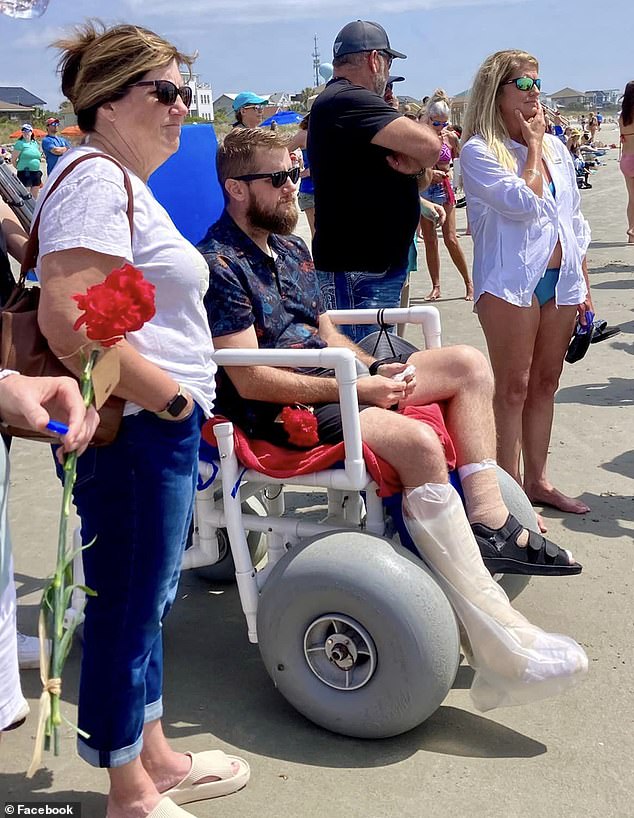 Aric Hutchinson was left wheelchair-bound after suffering two leg fractures, multiple facial fractures and a concussion. He is seen here at a beachside memorial in memory of his late wife.
