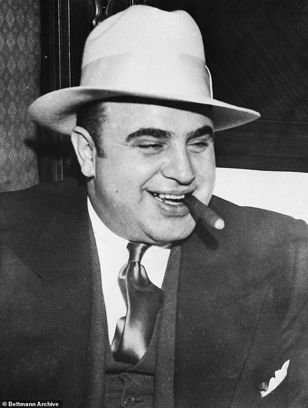 840 SEI*189648967 The infamous gangster Al Capone smokes a cigar on the train that takes him to the federal penitentiary in Atlanta, where he began serving his 11-year sentence.