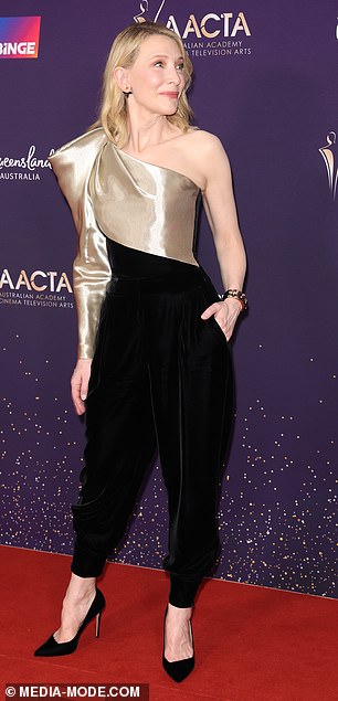 The 54-year-old Australian actress looked incredibly chic in a retro-style jumpsuit, which featured a one-sleeve metallic gold bodice and black velvet pants.