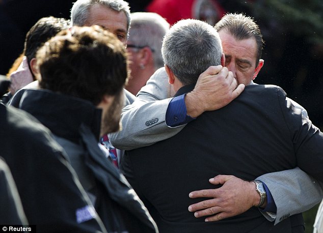 Tragedy: Mourners embrace after the funeral of men who drowned together in the storm surge caused by Superstorm Sandy.