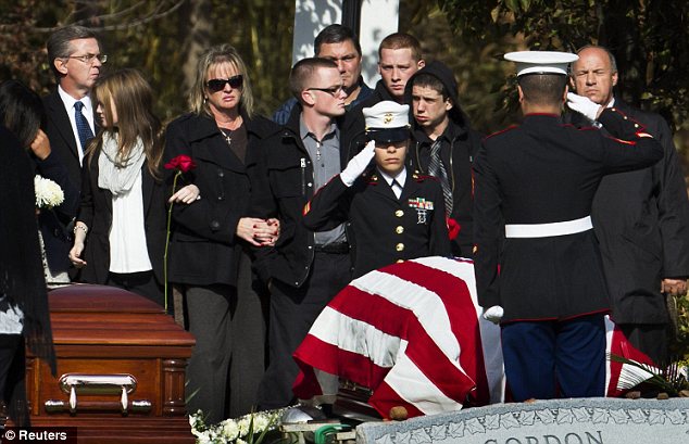 Final resting place: Christine Filipowicz watches as US Marines salute her husband's casket during funeral services