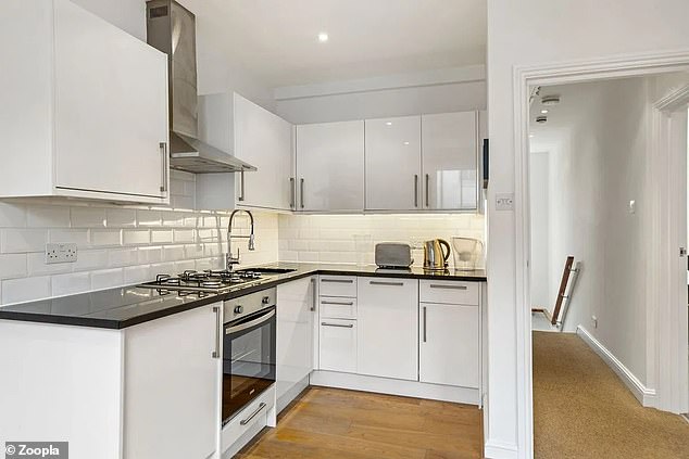 Notting Hill has a modern kitchen with white base and wall cabinets and a contrasting dark worktop