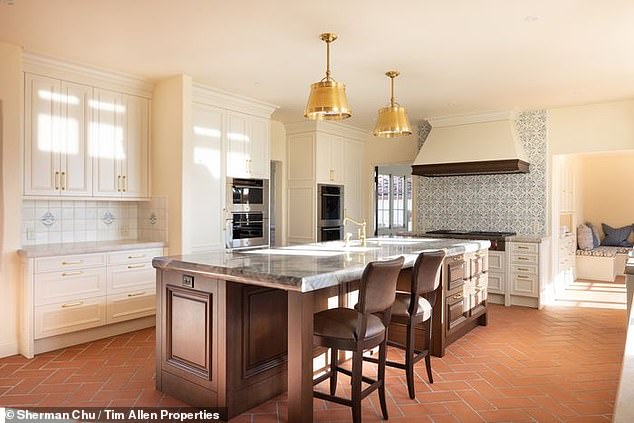 The property's kitchen has been recently renovated, but still shows the Spanish Renaissance influence in the bright backsplash tiles and rough symmetrical brick floor design.