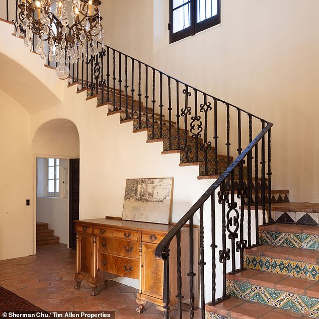 The recently renovated house retains much of its original character, including the Spanish influence, seen here in the tiles on the stairs and curved doors.