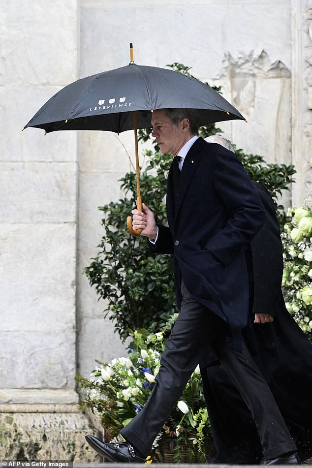 Prince Vittorio's son, Prince Emanuele Filiberto, was photographed entering the cathedral wearing a long black coat and shielding himself from the rain with an umbrella.