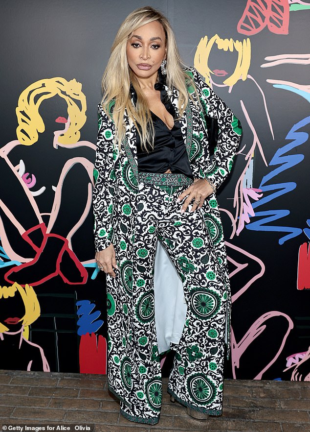 Karen Huger stood out in a three-tone printed jacket and matching pants, both paired with a black velvet blouse.