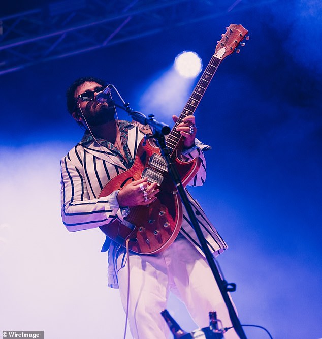 Dressed in a white striped shirt and white jeans, the musician looked incredibly stylish on stage as he hid his eyes behind a pair of dark sunglasses.