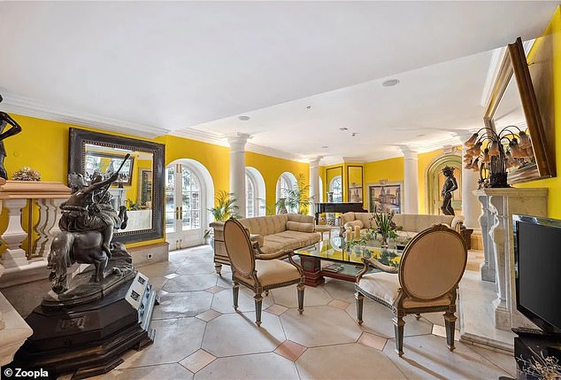 The opulence continues throughout the house, with a bright yellow room that includes several large white pillars.