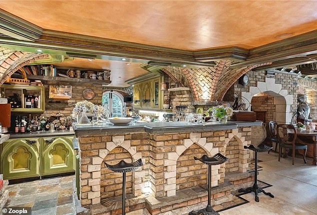 The kitchen has arched cabinets, a design that is replicated in the breakfast bar.