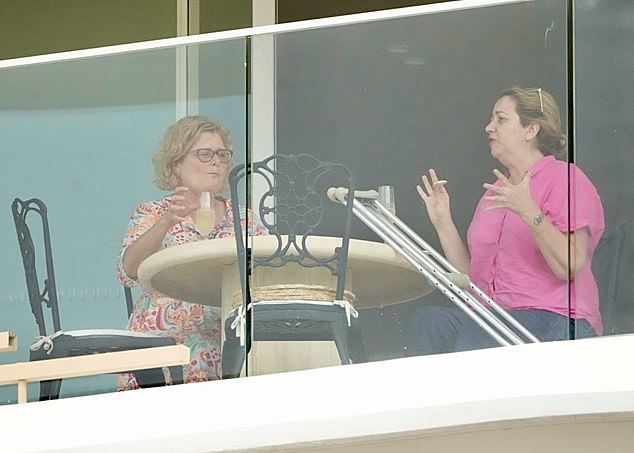 Ms Palaszczuk, who was wearing a light pink shirt and had her hair up, left her crutches propped up against the table and enjoyed some snacks and a glass of champagne with a female companion (pictured).