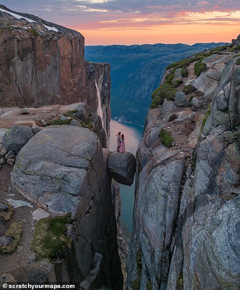 Danni and Fede find themselves on Kjeragbolten, a rock wedged into a crevice 984 m (3,228 ft) above sea level on Kjerag Mountain in the Lysefjord in Norway. This popular tourist destination can be reached without the need for hiking equipment.