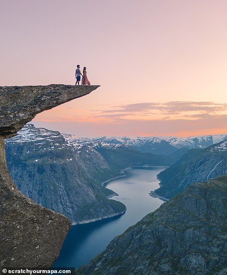 The couple is at the top of Trolltunga. One of the most amazing rock formations in Norway, 