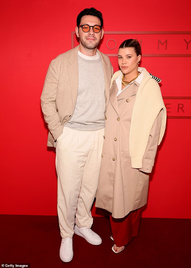 The brand's new ambassador donned a chic tan trench coat as she arrived at the soirée alongside her handsome husband Elliot Grainge.