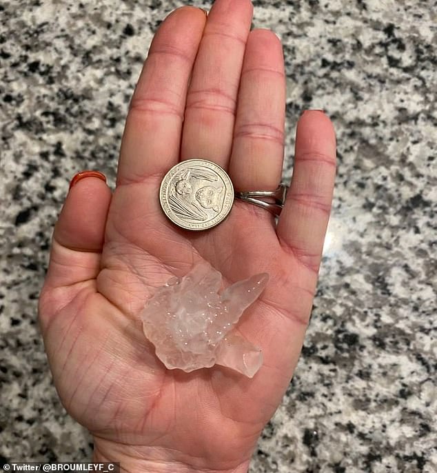 A Whitehouse, Texas, resident is seen holding a large piece of hail in his hand and compared it to a quarter on Sunday.