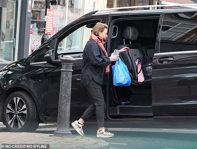 She combed her short hair back and appeared to go makeup-free as she climbed into a black van with her shopping in tow.