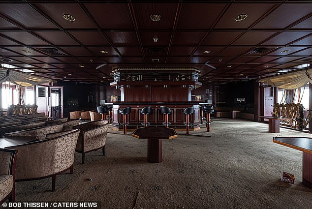 A large room inside the ship appears haunted, as the chairs are still in place and trash is visible on the floor.