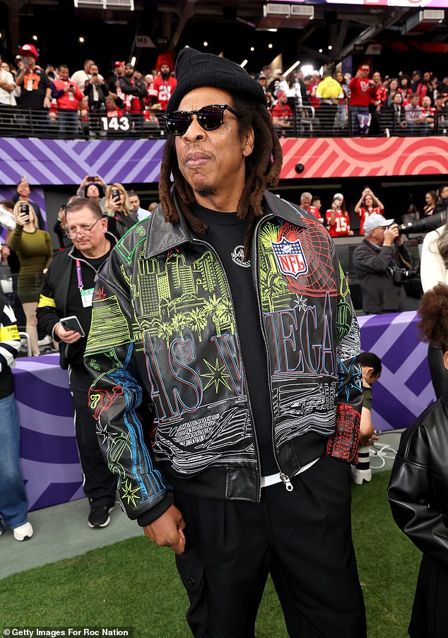 Jay-Z donned a black printed jacket over a black top with black pants, a beanie and sunglasses.