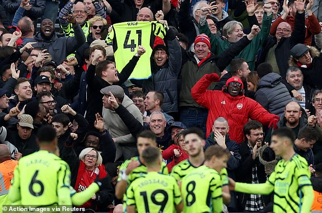 Arsenal fans delightfully celebrate Rice's goal, holding the England international's shirt in the stands.