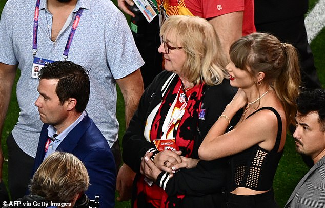 Watching closely, girlfriend Taylor Swift held hands with Travis' mother, Donna.