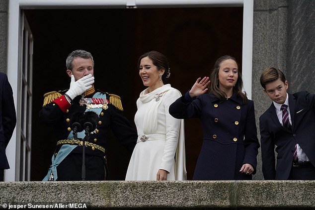 Queen Mary laughs while standing on the balcony of Christiansborg Castle with her family.