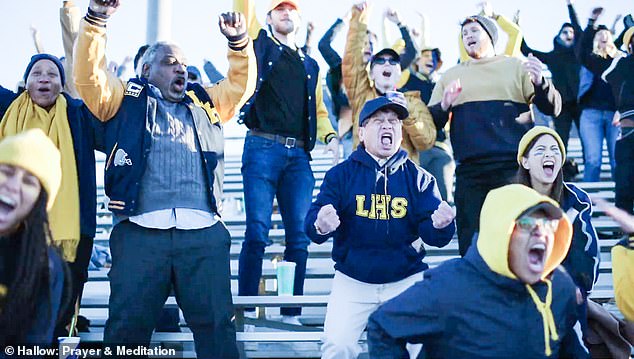 A group applauds while watching a game.