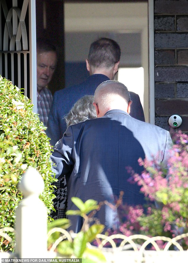 Albanese donned a plaid shirt and jeans while hosting officials at his home.