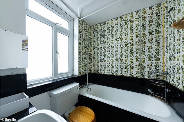 This bathroom has a white suite surrounded by contrasting black and colorful wall coverings.