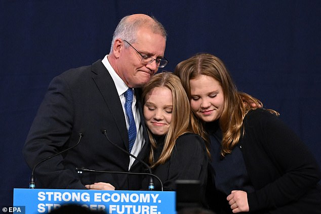 Morrison is seen hugging his two daughters after losing the election on Saturday night.